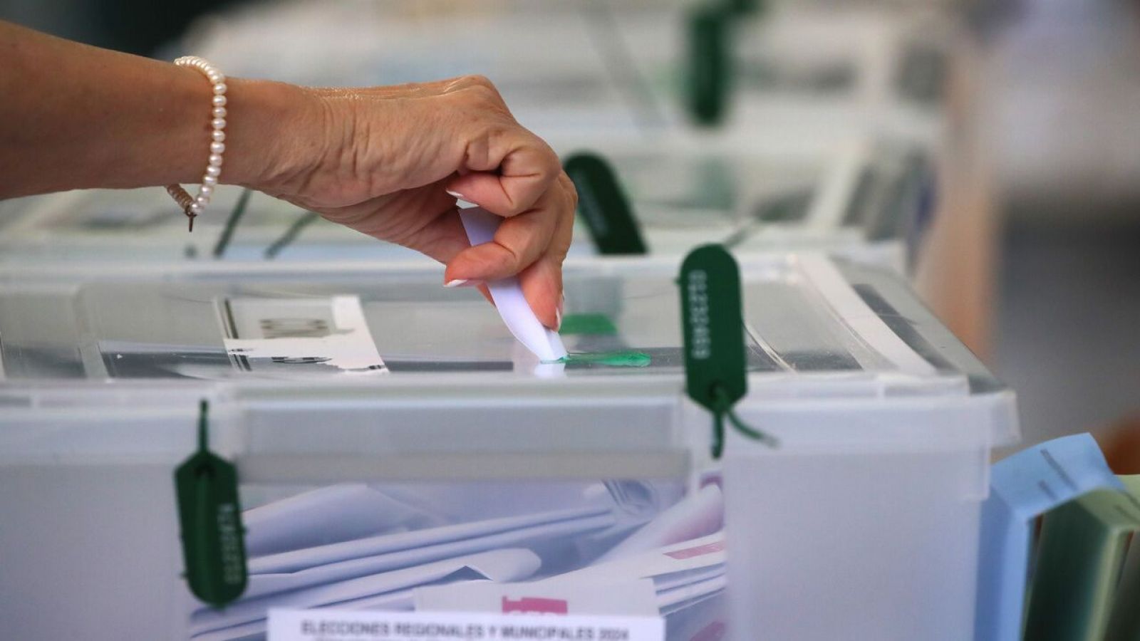 Mano emitiendo voto en una urna para elecciones