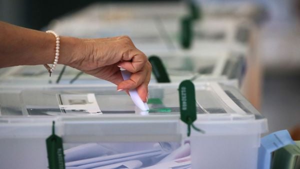 Mano emitiendo voto en una urna para elecciones