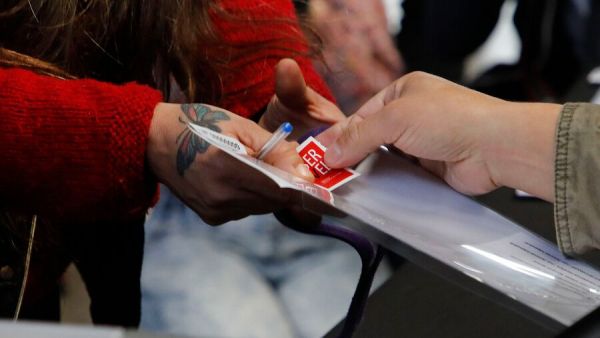 Mano recibiendo un voto en elecciones.