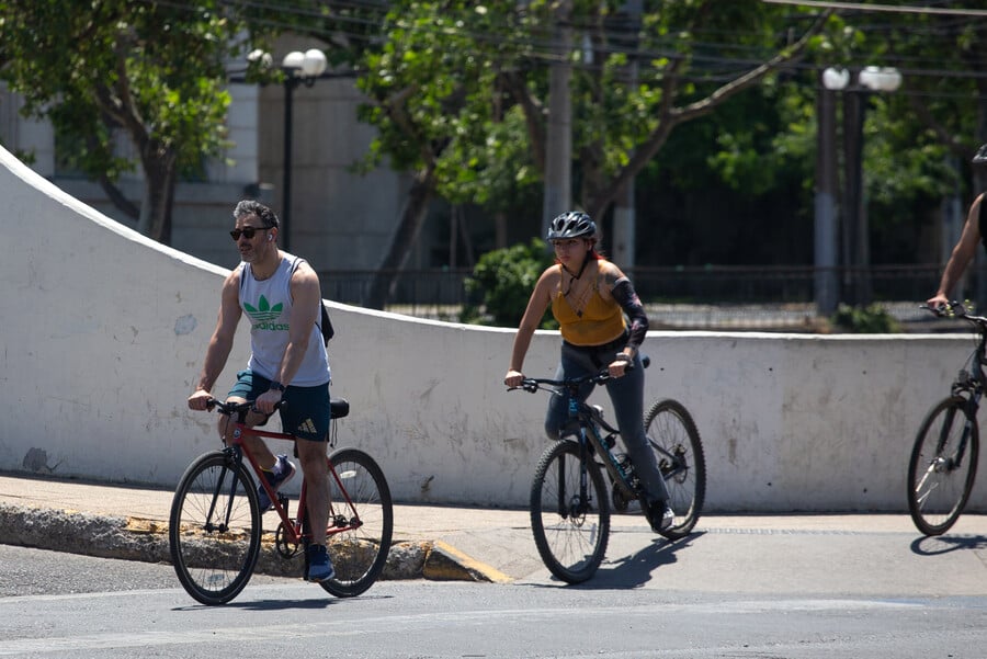 Personas andando en bicicleta en el calor en Santiago