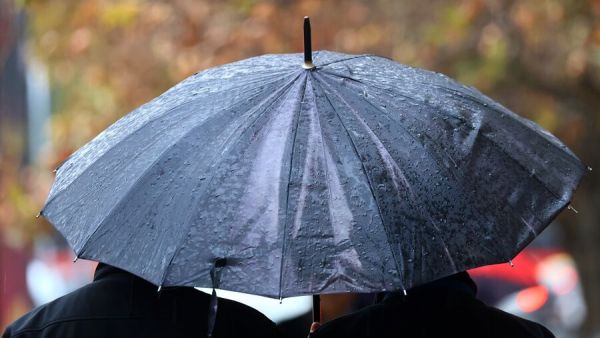 Personas bajo la lluvia en paraguas.
