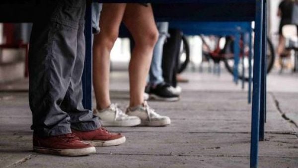 Mesas de votación y personas esperando para votar