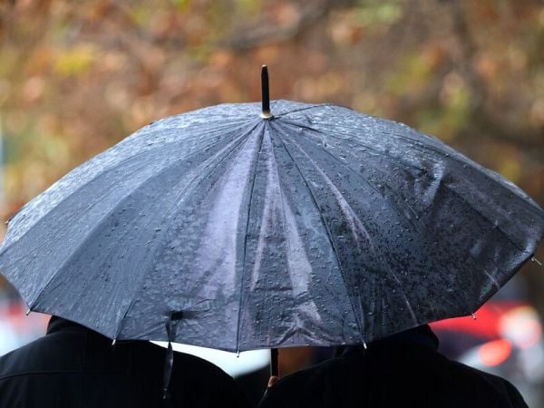 Personas bajo la lluvia en paraguas.