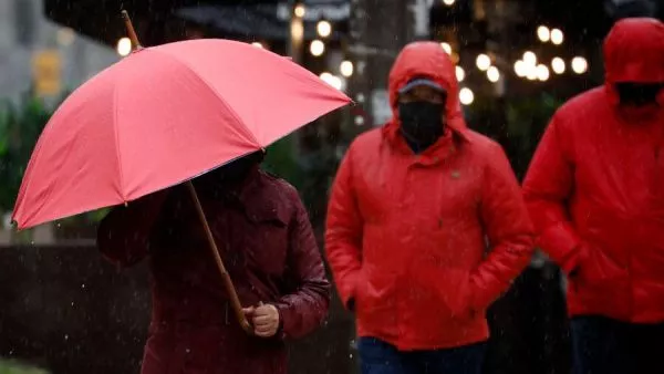 Persona bajo la lluvia en paraguas. Tormenta
