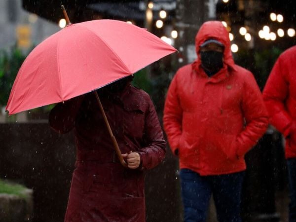Persona bajo la lluvia en paraguas. Tormenta