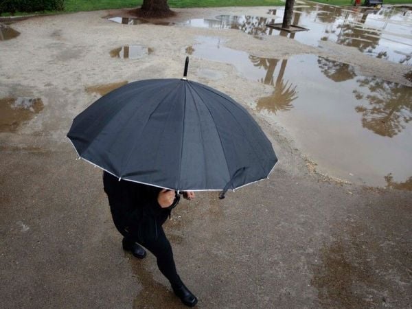 Persona bajo la lluvia con paraguas.