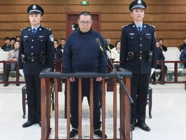 Bai Tianhui junto a dos policías al costado.