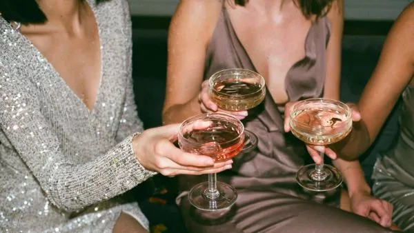 Mujeres con copas en la mano brindando.