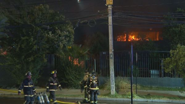 Bomberos en bodegas intentando apagar el incendio.