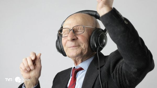 Persona adulta mayor escuchando música con audífonos como estimulación cognitiva.