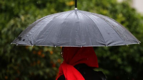 Personas bajo la lluvia en paraguas.