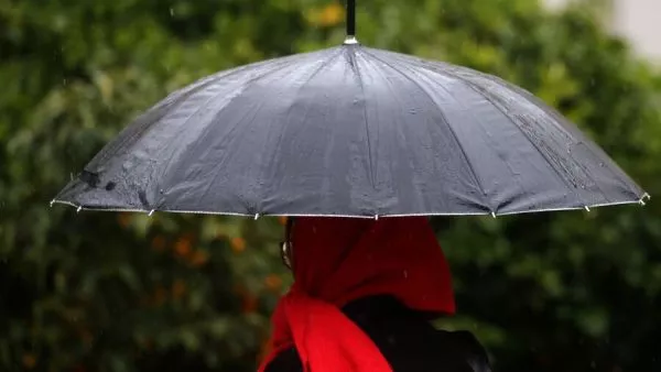 Personas bajo la lluvia en paraguas.