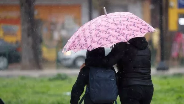 Personas bajo la lluvia con paraguas.
