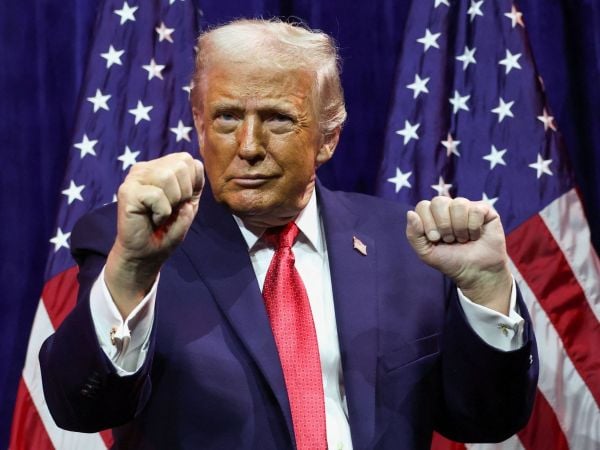 El presidente de Estados Unidos, Donald Trump con lo puños arriba celebrando.