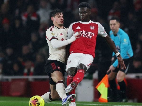 Milos Kerkez y Bukayo Saka disputando un balón