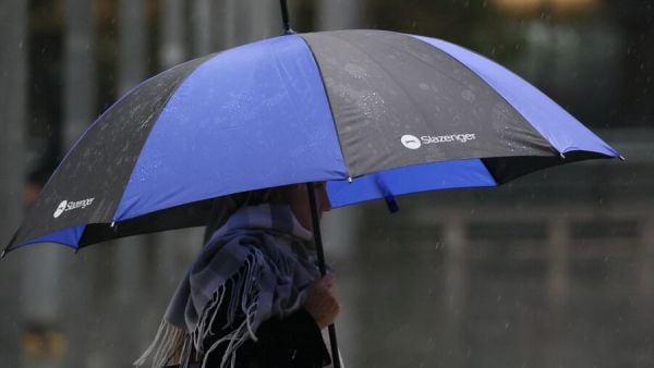 Personas bajo la lluvia con paraguas.