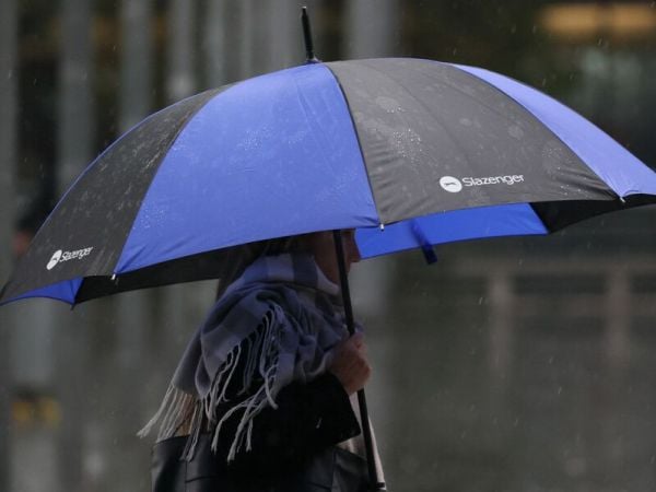 Personas bajo la lluvia con paraguas.