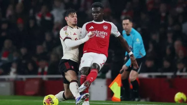 Milos Kerkez y Bukayo Saka disputando un balón