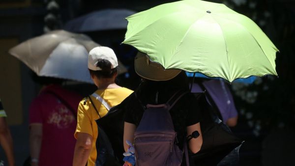 Persona con sombrilla bajo el sol en Santiago