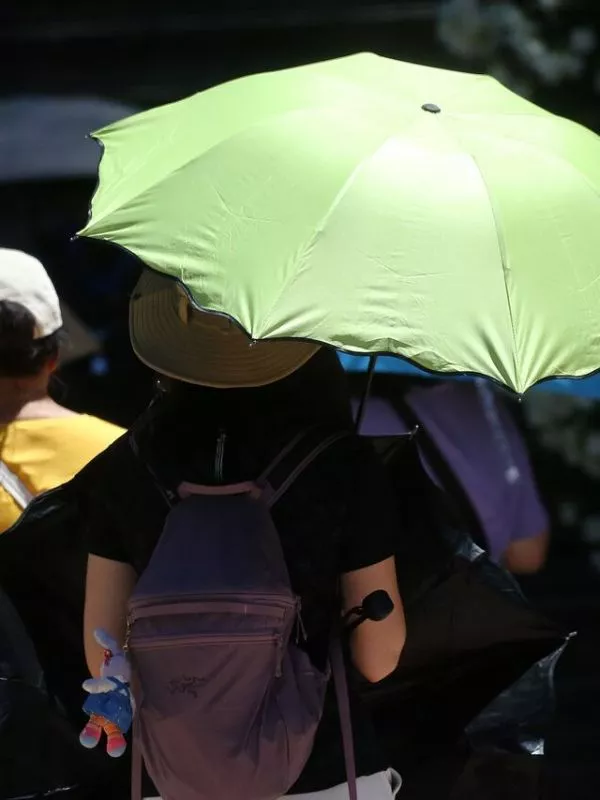 Persona con sombrilla bajo el sol en Santiago