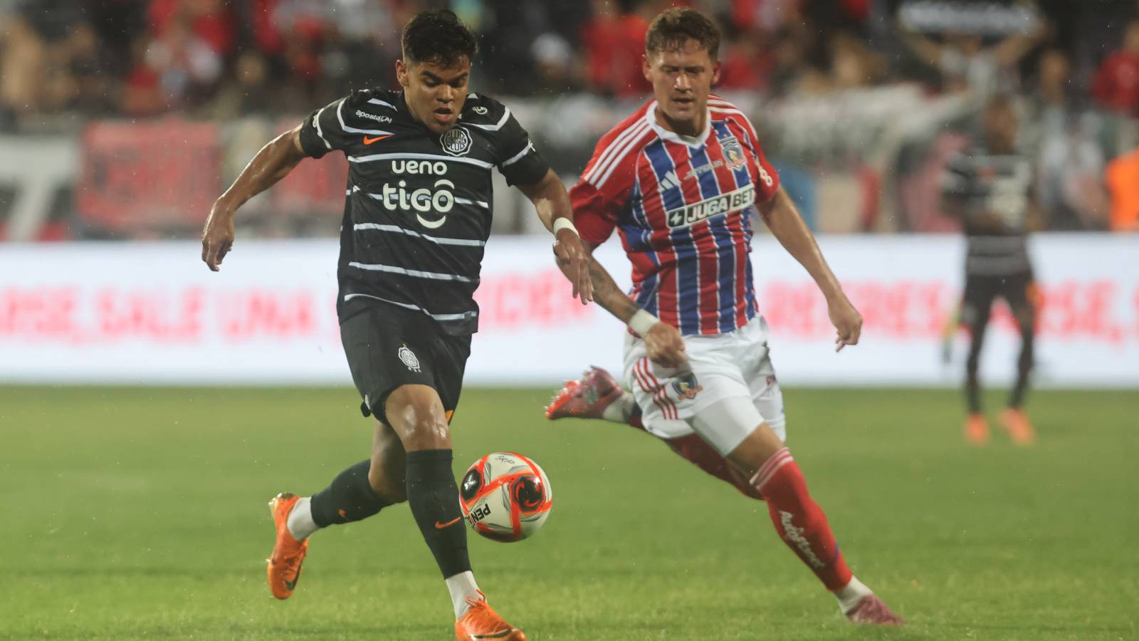 El jugador de Colo Colo, Javier Méndez, disputa el balon contra Junior Barreto de Olimpia durante el partido amistoso por la Serie Rio de La Plata