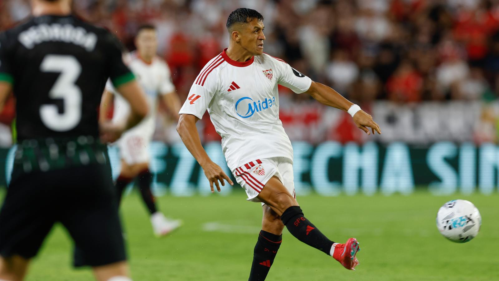 Alexis Sánchez dando un pase en un partido con el Sevilla