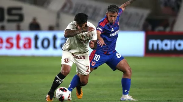 Caín Fara de Universitario disputa un balón con Lucas Assadi de Universidad de Chile