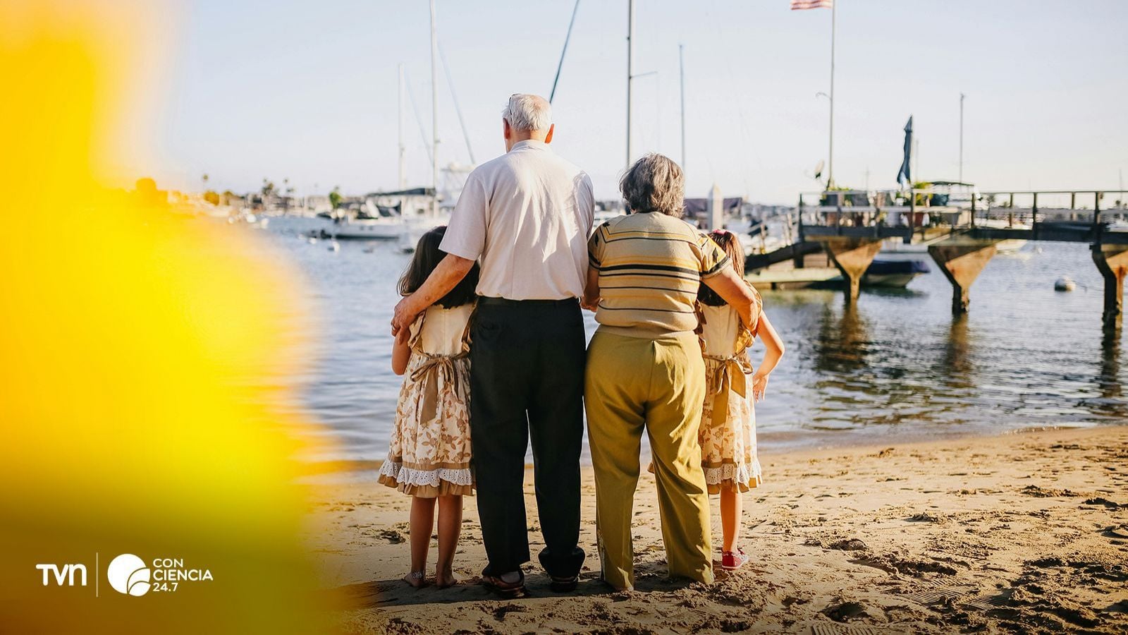 Abuelos cuidando de sus nietos en la playa.