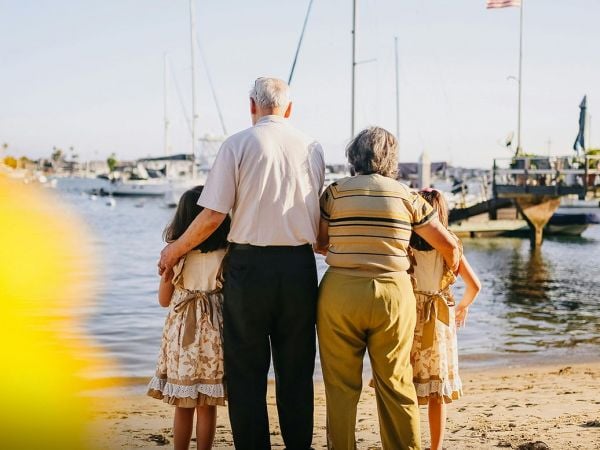 Abuelos cuidando de sus nietos en la playa.