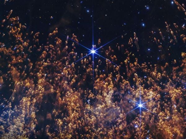 Imagen de la Nebulosa de la Hélice captada por el telescopio James Webb, mostrando columnas de gas, polvo y una enana blanca en el centro.