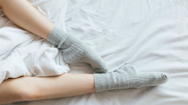 Persona durmiendo con calcetines. Foto referencial.