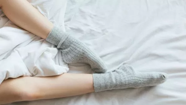 Persona durmiendo con calcetines. Foto referencial.