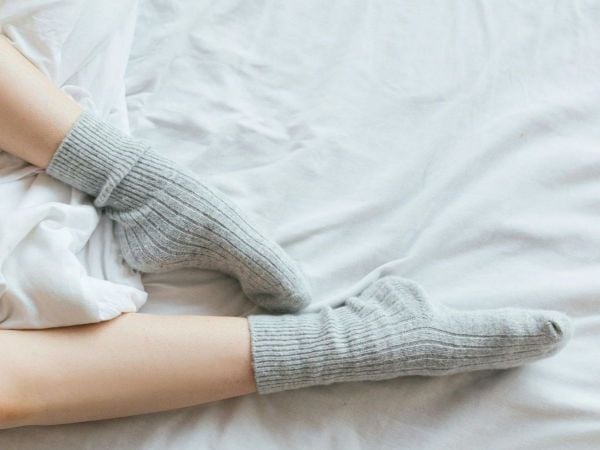 Persona durmiendo con calcetines. Foto referencial.