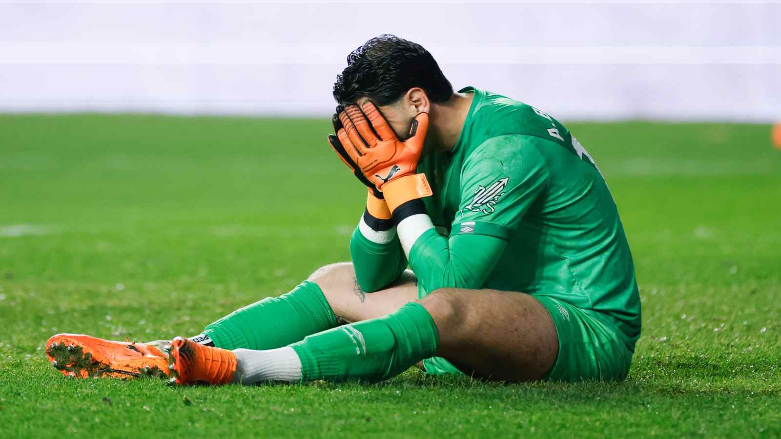 Augusto Batalla lamentándose tirado en el pasto de una cancha de fútbol