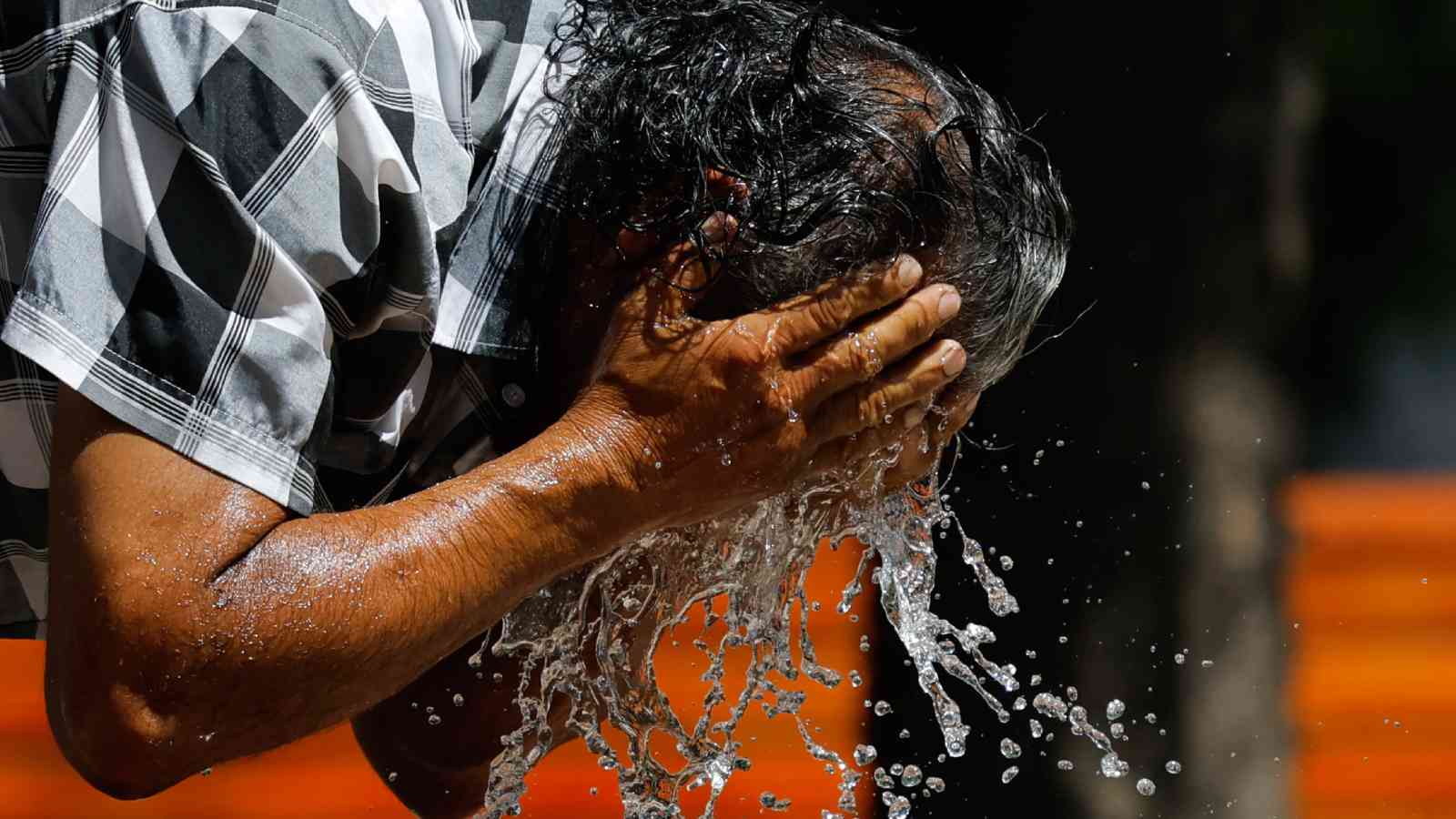 Hombre refrescándose del calor con agua