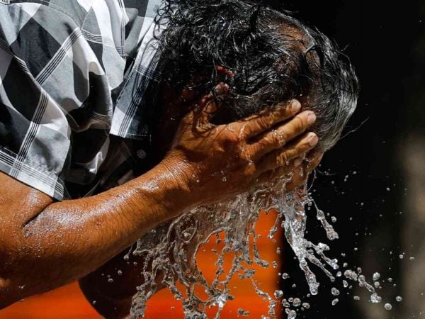 Hombre refrescándose del calor con agua