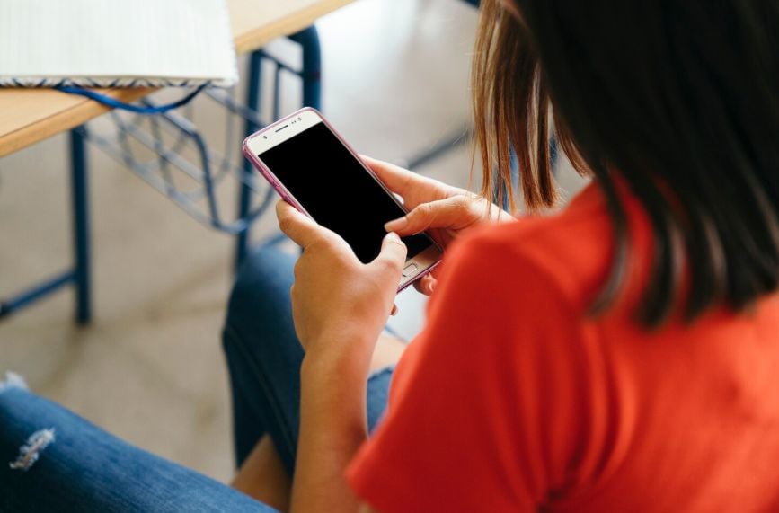 Estudiante con celular en colegio