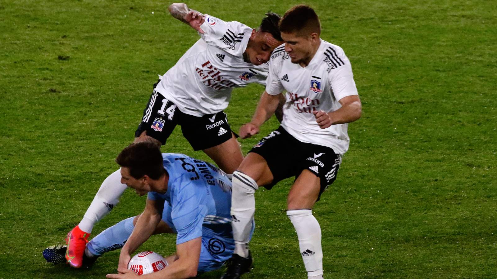 Martín Rodríguez y Leonardo Gil luchando un balón frente a un jugador de O'Higgins