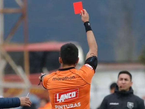 Árbitro sacando tarjeta roja a una banca