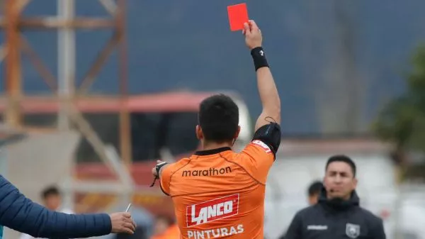 Árbitro sacando tarjeta roja a una banca
