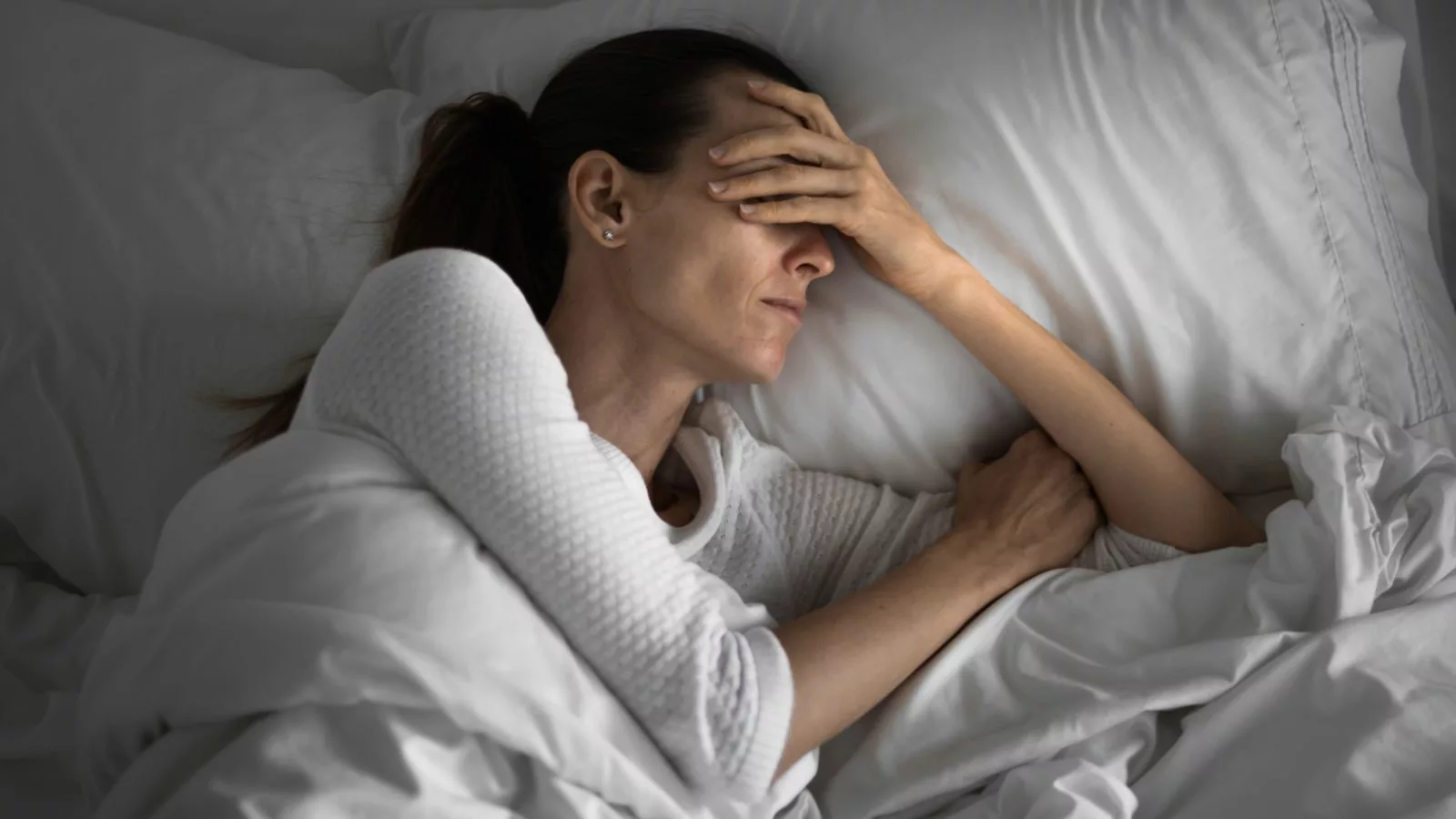 Persona con problemas para dormir en su cama