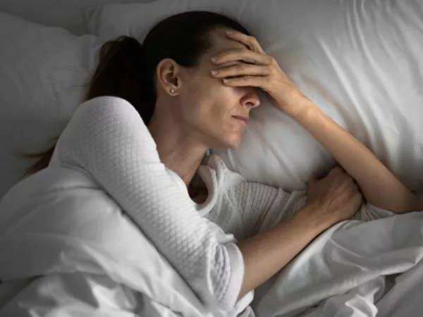 Persona con problemas para dormir en su cama