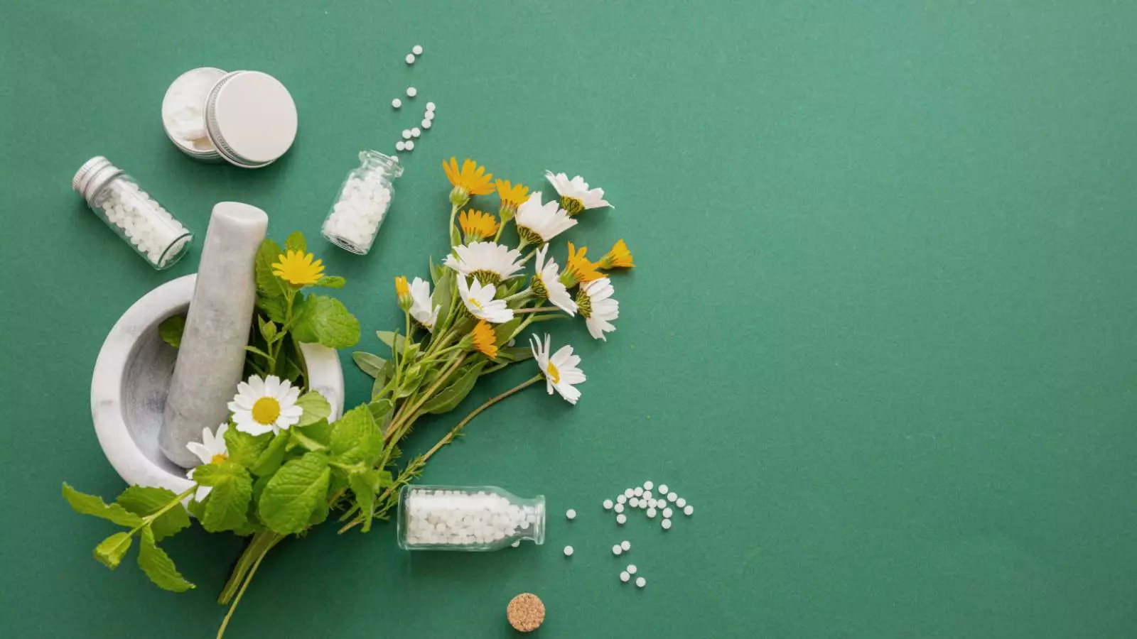 Flores en un mortero y pastillas de homeopatía