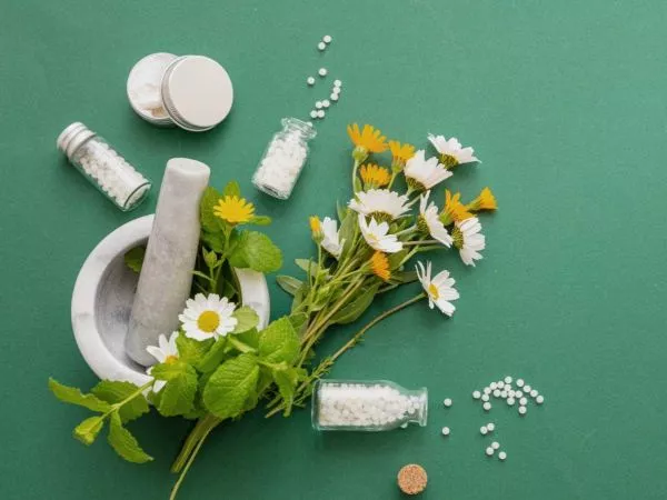 Flores en un mortero y pastillas de homeopatía