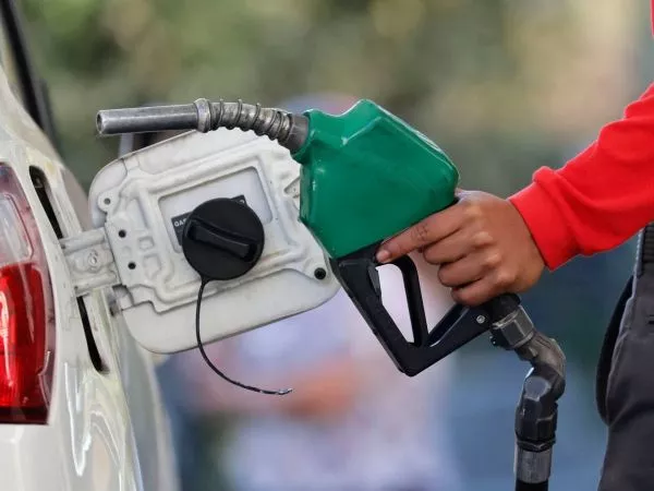 Persona cargando combustible en una bencinera