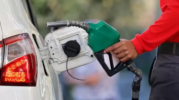 Persona cargando combustible en una bencinera