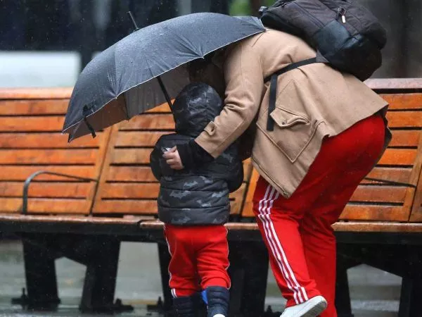 Niño y su madre bajo la lluvia en el centro de Santiago