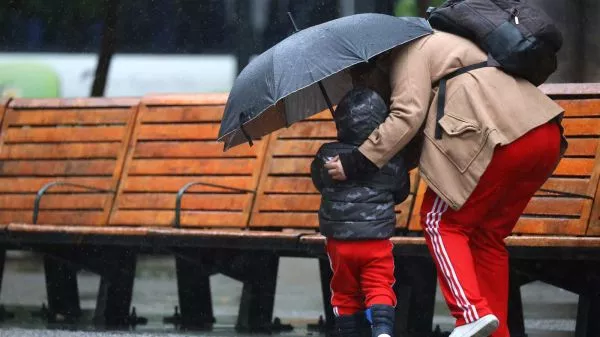 Niño y su madre bajo la lluvia en el centro de Santiago