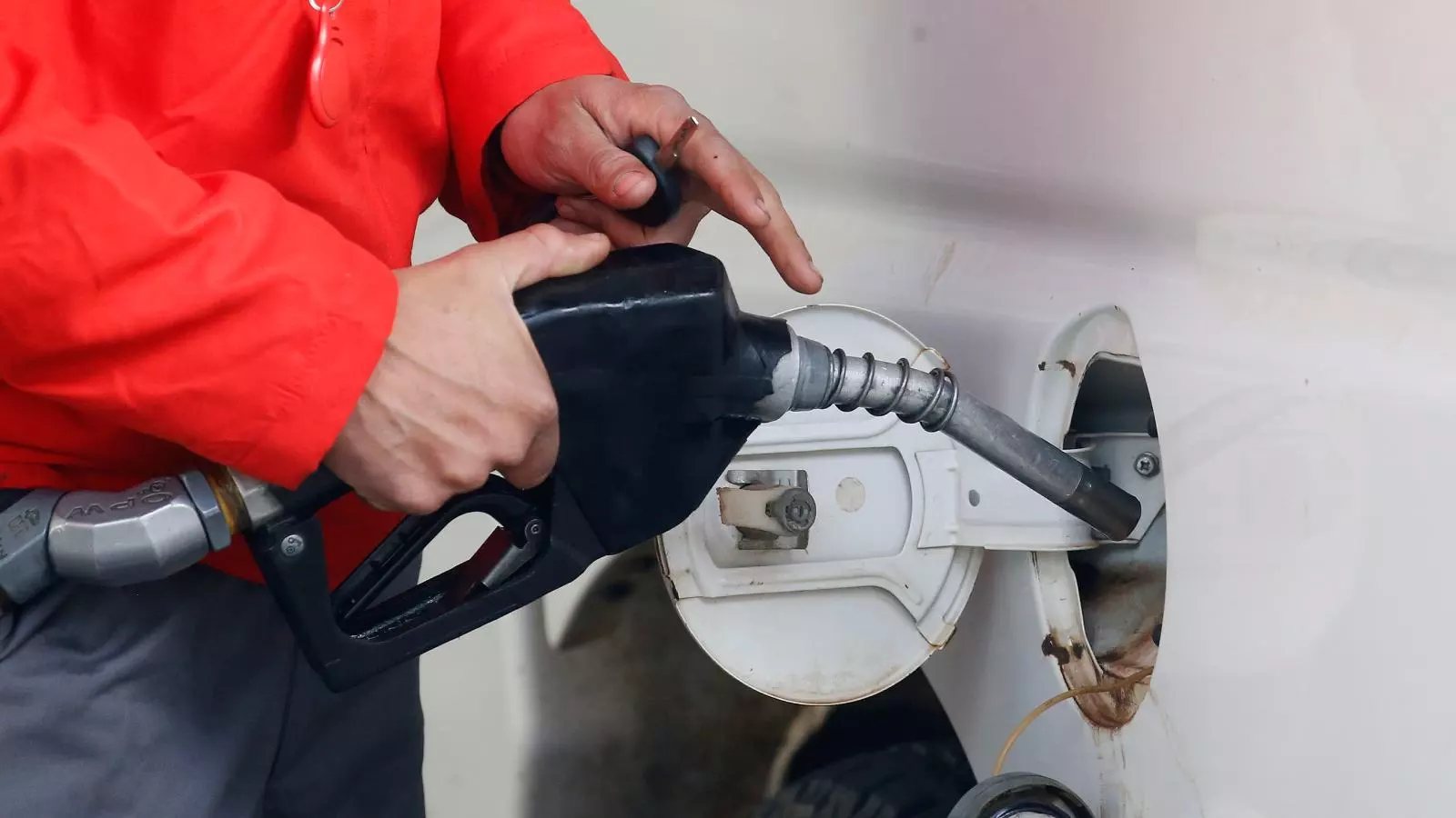 Persona cargando combustible en una bencinera
