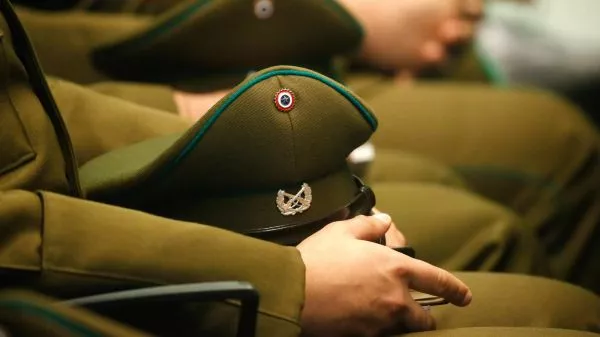 Carabinero sentado tomando su gorra